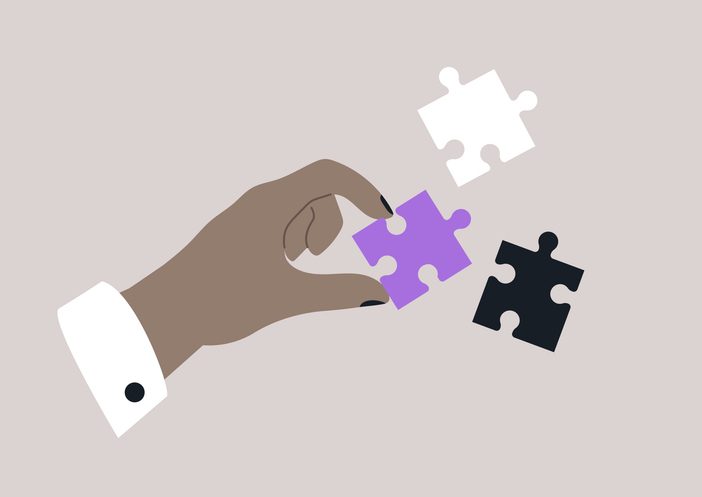 A hand is skillfully selecting a vibrant puzzle piece from a collection of intriguing shapes and colors, perfectly enhancing the creative atmosphere of the moment